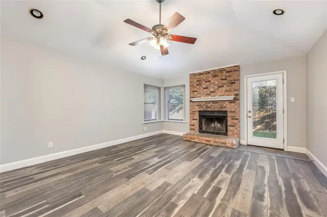 a view of an empty room with a fireplace and a window