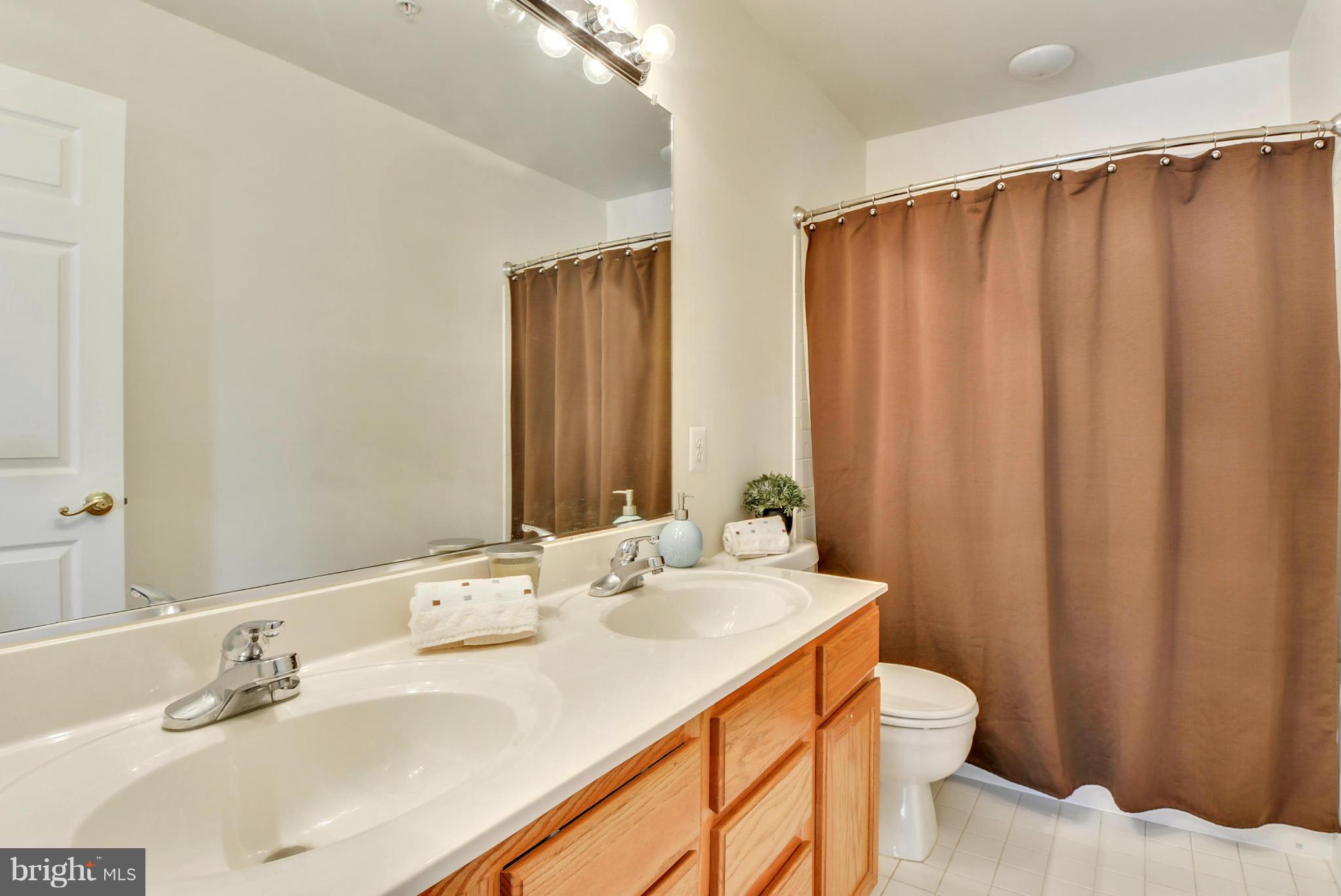 15509 Overchase Lane Bowie, MD 20715 - Photo 19 of 30 a bathroom with a sink a toilet and shower curtain