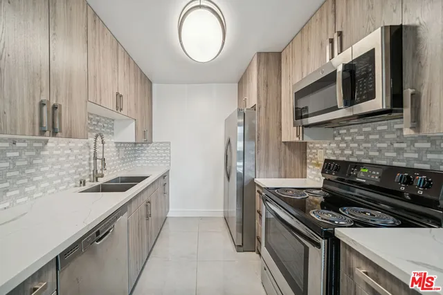 a kitchen with stainless steel appliances granite countertop a sink and a stove