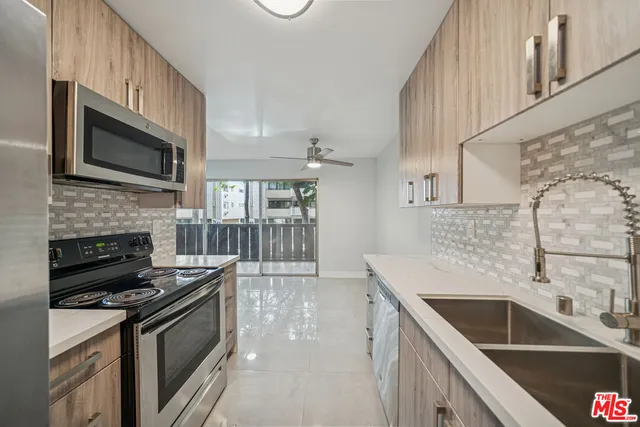 a kitchen with stainless steel appliances granite countertop a sink and stove top oven