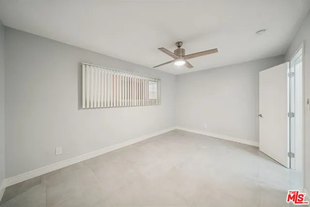 an empty room with a window and a ceiling fan