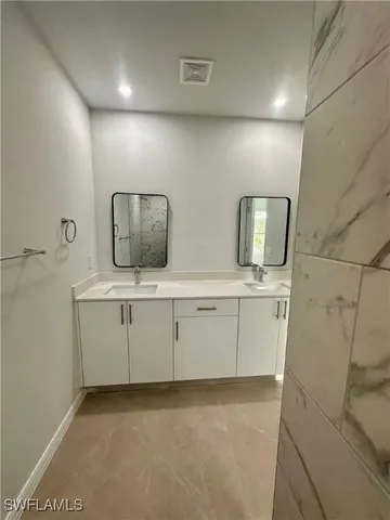 a bathroom with 2 sink and a mirror