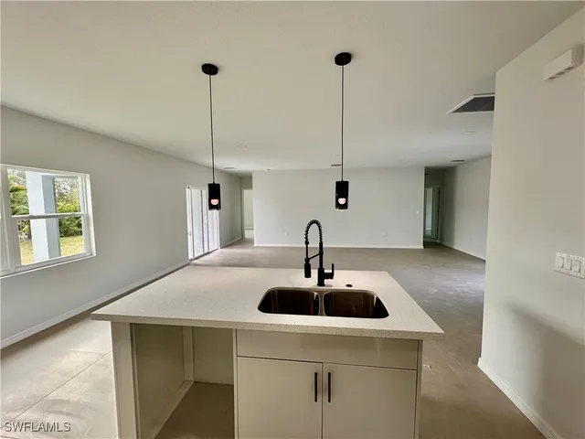 a kitchen with a sink a counter space and a refrigerator