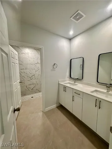 a bathroom with double vanity sink and mirror