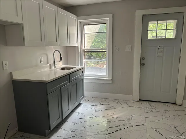 a kitchen with a sink window and cabinets