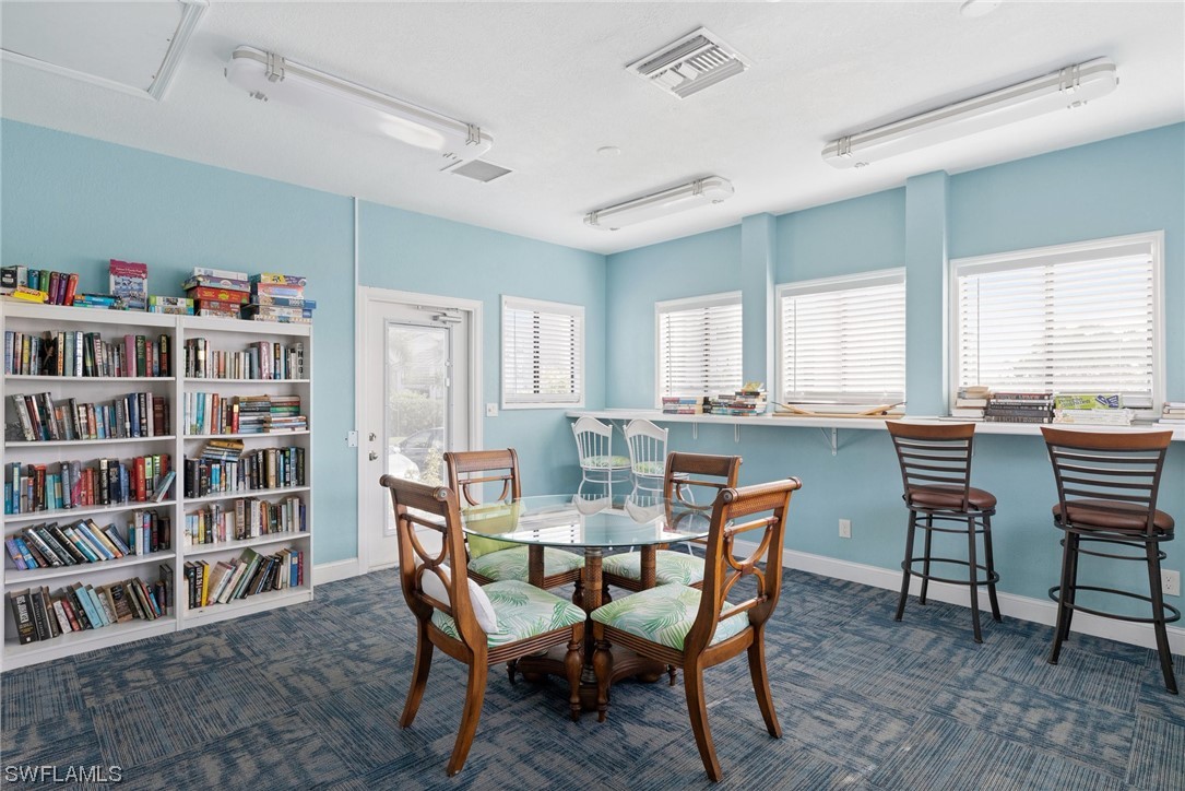 13571 Eagle Ridge Drive, Unit 1325 Fort Myers, FL 33912 - Photo 21 of 26 a dining room with a bookshelf and a dining table