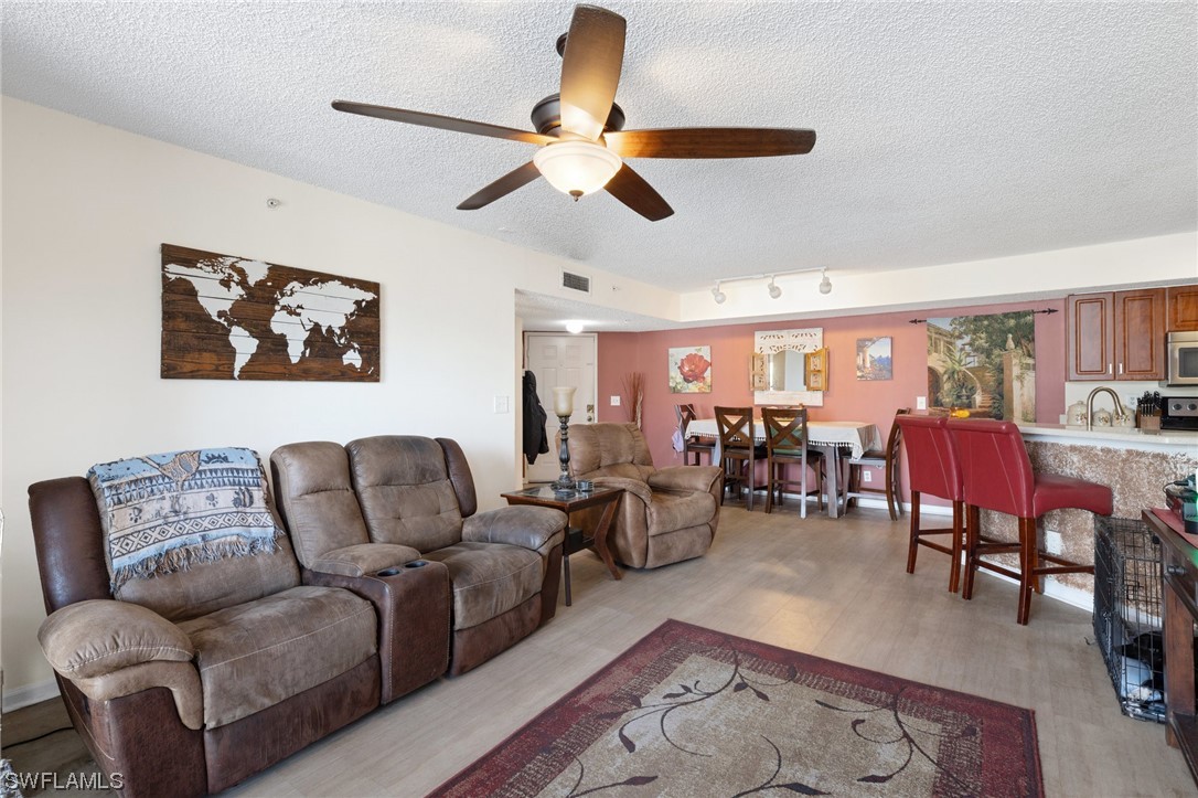 13571 Eagle Ridge Drive, Unit 1325 Fort Myers, FL 33912 - Photo 5 of 26 a living room with furniture a chandelier and a rug
