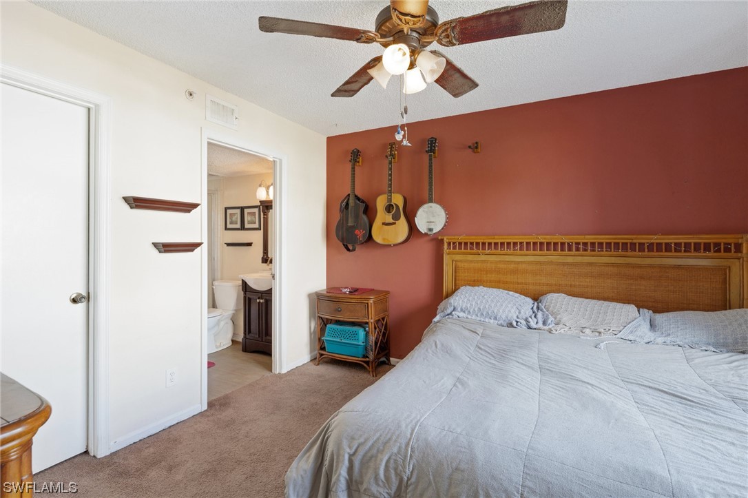 13571 Eagle Ridge Drive, Unit 1325 Fort Myers, FL 33912 - Photo 10 of 26 a bedroom with a bed and a chandelier