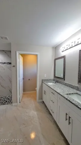 a bathroom with a granite countertop sink and a mirror