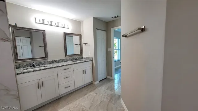a bathroom with a granite countertop sink and a mirror