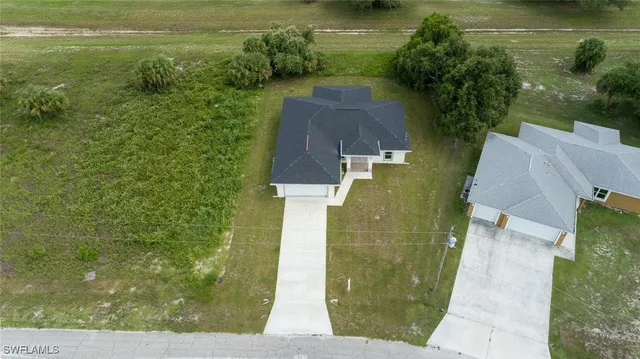 an aerial view of residential houses with outdoor space and swimming pool