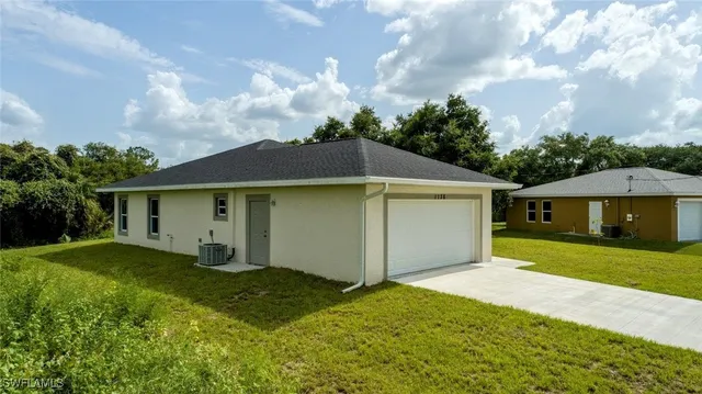 a view of a house with a yard and garage