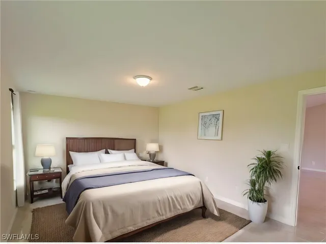 a bedroom with a bed and a potted plant