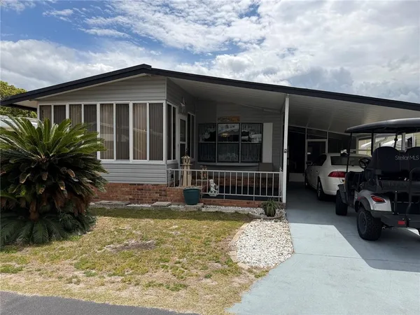 a view of a house with a patio and a yard
