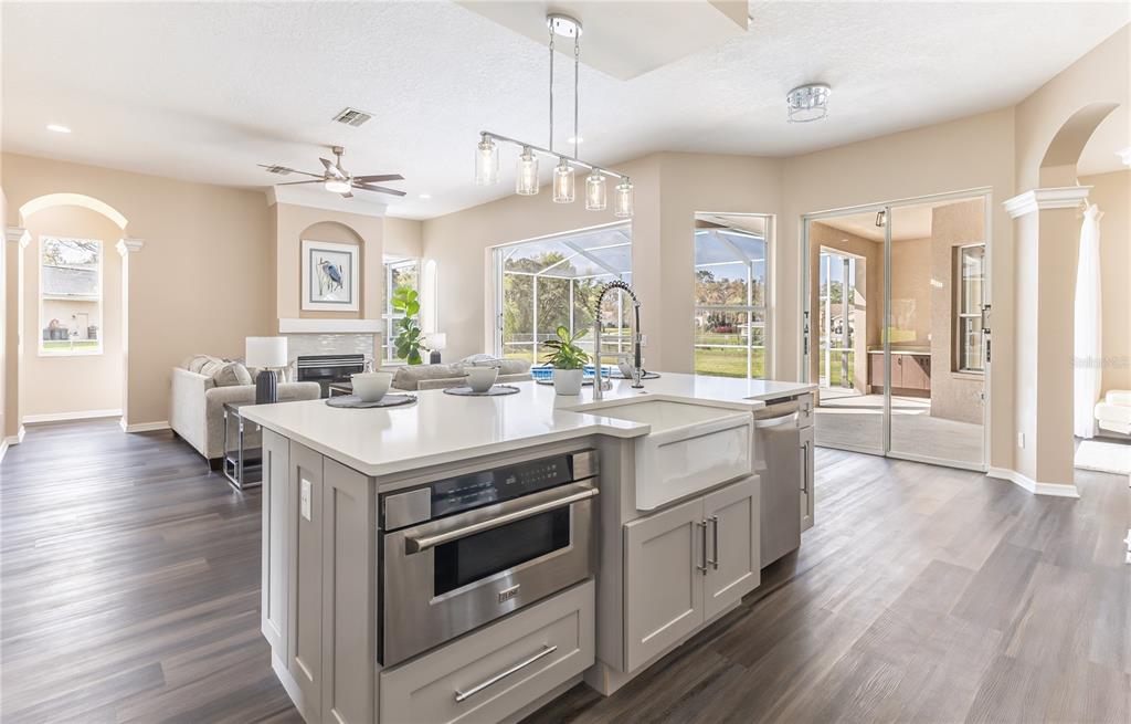12230 Padron Boulevard Spring Hill, FL 34609 - Photo 7 of 22 a kitchen with stainless steel appliances wooden floor sink and stove