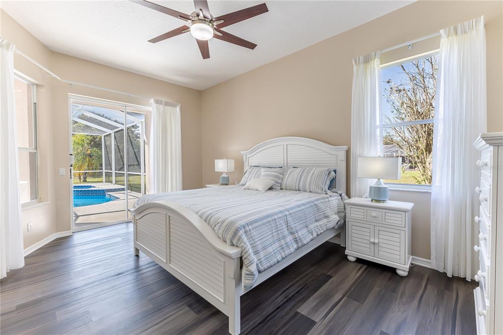 12230 Padron Boulevard Spring Hill, FL 34609 - Photo 9 of 22 a bedroom with a bed lamp and a large window