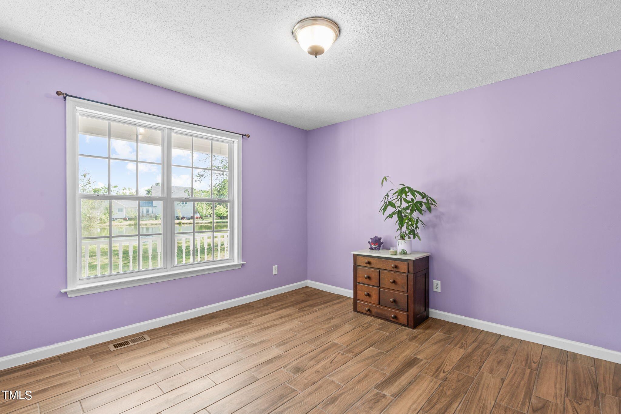 128 Edmondson Drive Willow Spring, NC 27592 - Photo 13 of 38 an empty room with a window and wooden floor