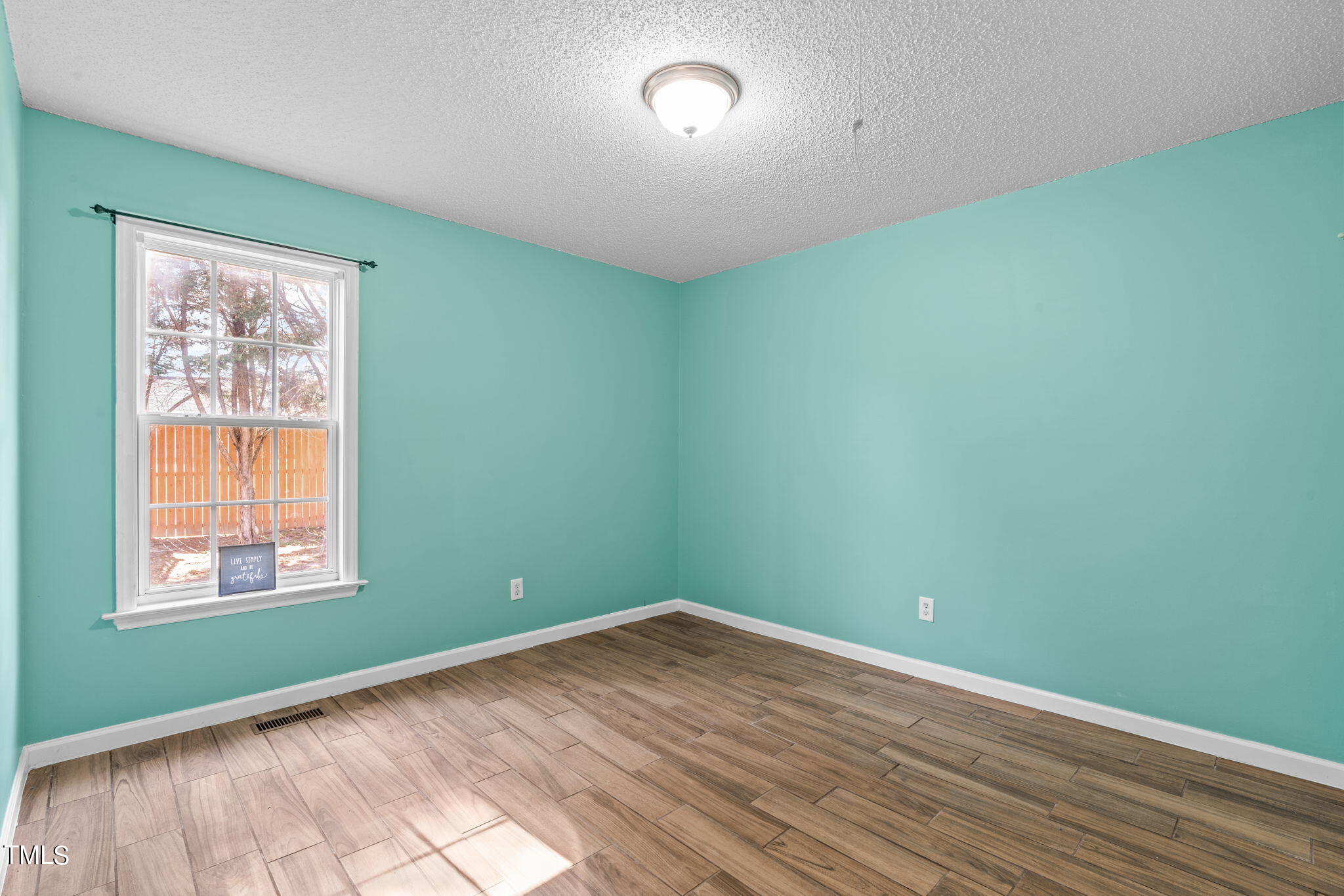 128 Edmondson Drive Willow Spring, NC 27592 - Photo 23 of 38 an empty room with wooden floor and windows