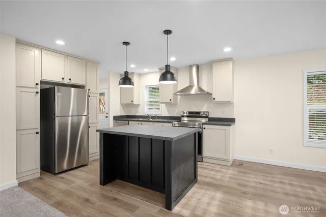 a kitchen with stainless steel appliances granite countertop a refrigerator a sink and a stove