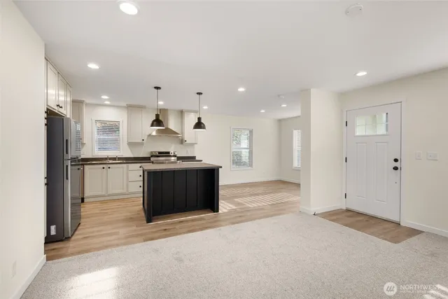 a kitchen with stainless steel appliances granite countertop a refrigerator and a stove