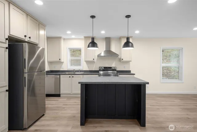 a kitchen with kitchen island stainless steel appliances a sink stove and refrigerator