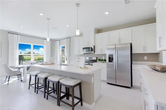 a kitchen with refrigerator a stove a table and chairs