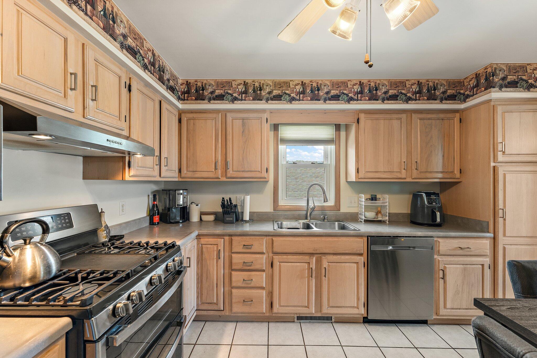 658 Forest Avenue Griffith, IN 46319 - Photo 11 of 31 a kitchen with stainless steel appliances granite countertop a stove a sink dishwasher and cabinets with wooden floor