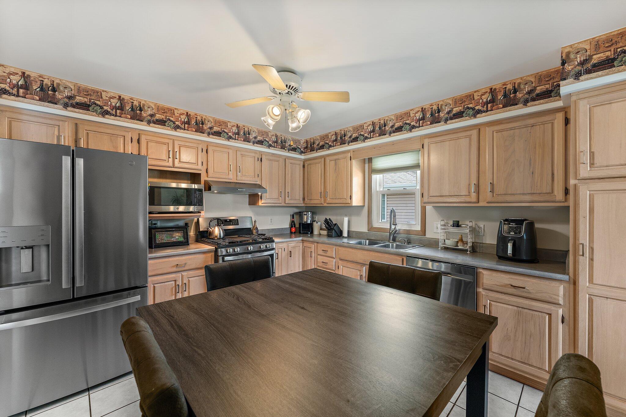 658 Forest Avenue Griffith, IN 46319 - Photo 15 of 31 a kitchen with granite countertop a refrigerator a stove a sink dishwasher a dining table and chairs with wooden floor