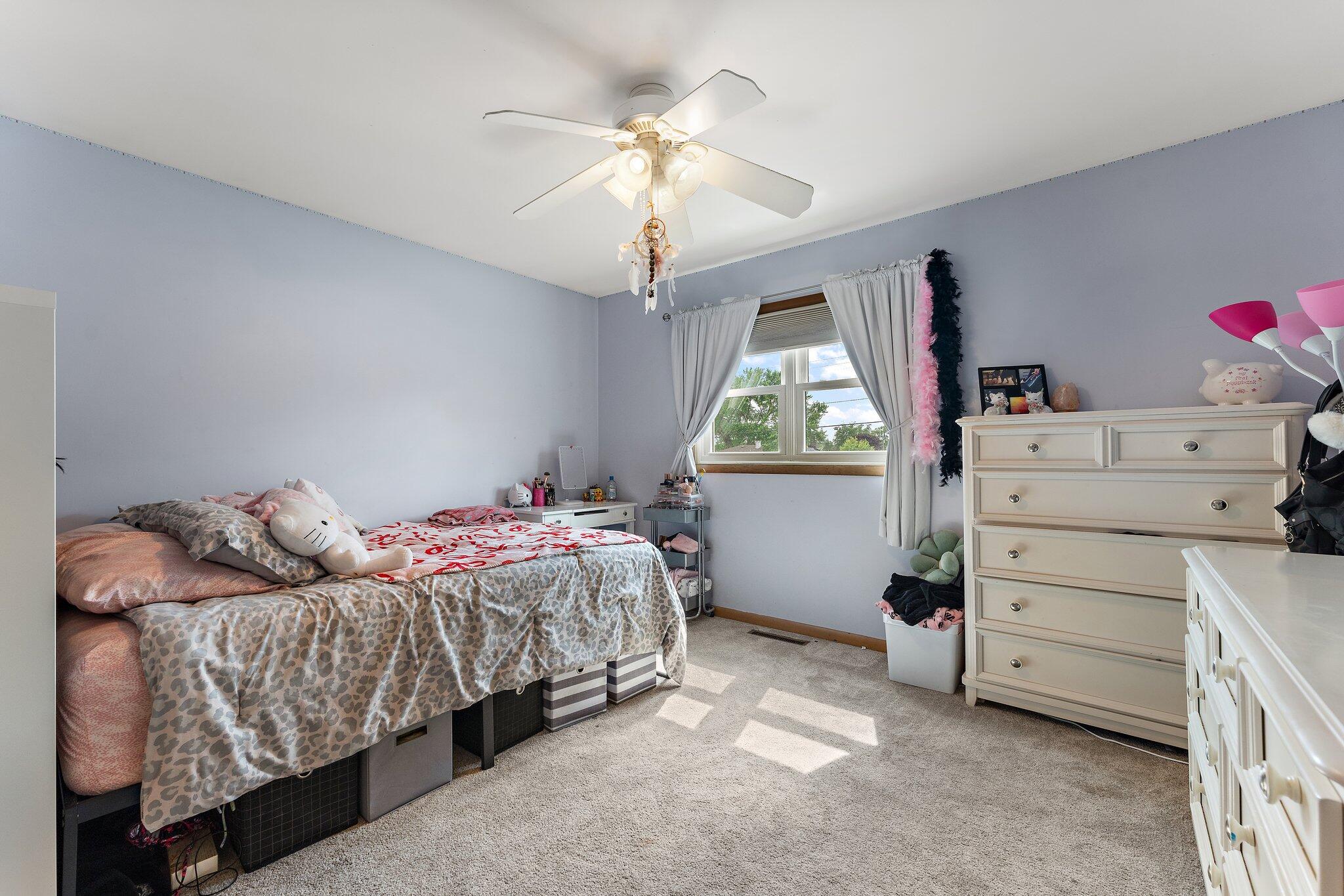 658 Forest Avenue Griffith, IN 46319 - Photo 18 of 31 a bedroom with a bed and a chandelier