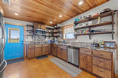 a bathroom with a granite countertop sink a toilet and a mirror