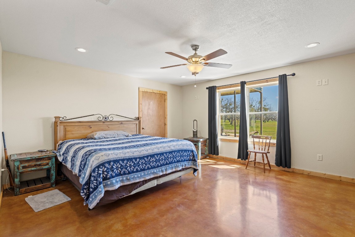 723 Fm 2926 Baird, TX 79504 - Photo 18 of 26 a spacious bedroom with a large bed and a chandelier