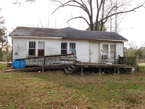a backyard of a house with barbeque oven and table