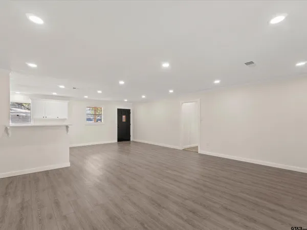 a view of empty room with wooden floor