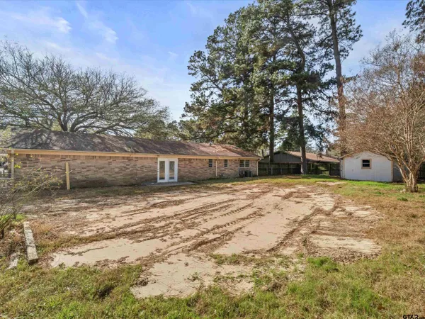 a view of a house with a yard and wooden fence
