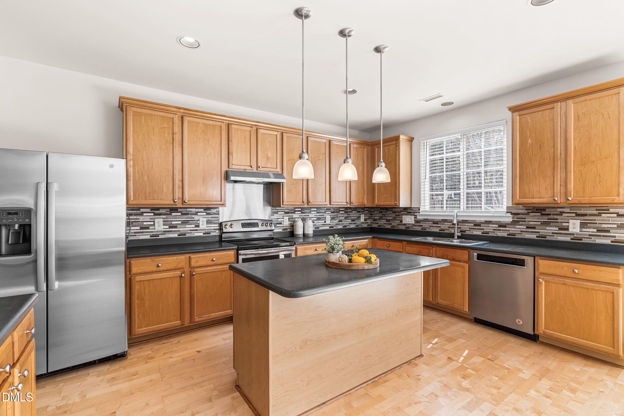 113 Cupp Court Raleigh, NC 27603 - Photo 9 of 29 a kitchen with stainless steel appliances granite countertop a sink a stove a refrigerator a center island and a window