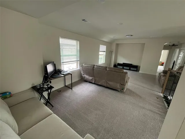 a view of a livingroom with workspace and windows