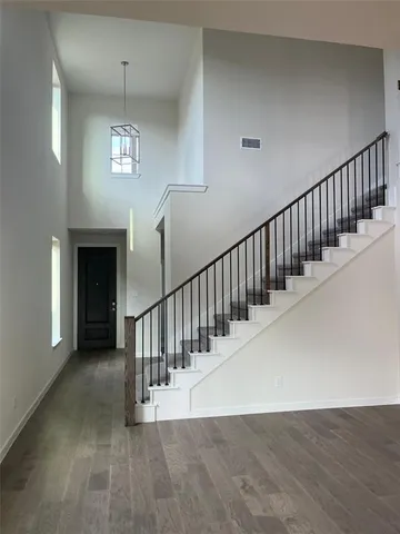 a view of a hallway with stairs and chandelier