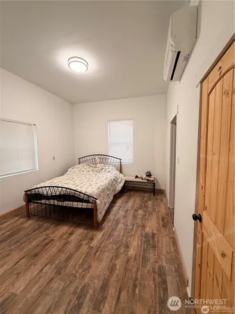 a bedroom with a bed and wooden floor