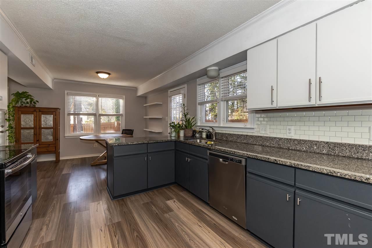 3628 Wickersham Way Raleigh, NC 27604 - Photo 5 of 21 a kitchen with granite countertop a stove a sink dishwasher and cabinets with wooden floor
