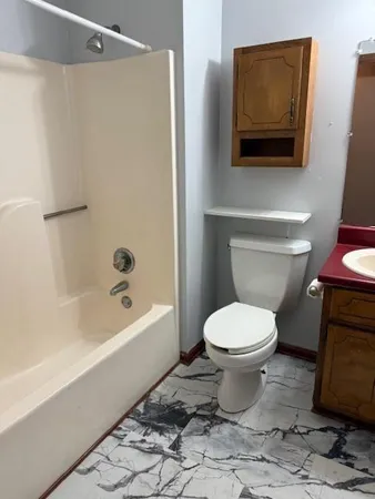 a bathroom with a toilet a sink and bathtub