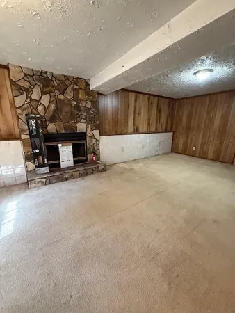 a view of an empty room with a fireplace and a window