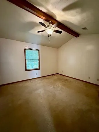 an empty room with windows and ceiling fan