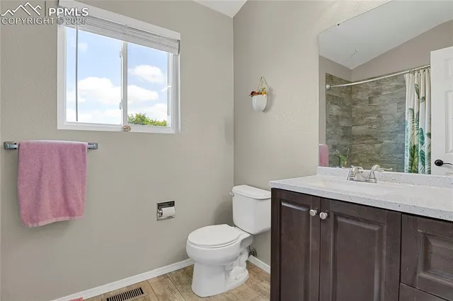 a bathroom with a granite countertop sink a toilet and a mirror