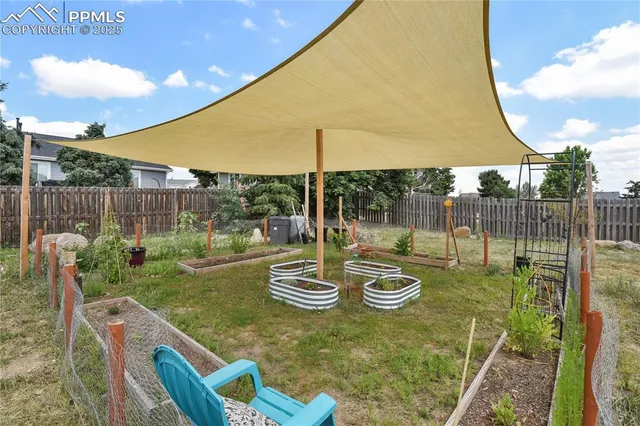 a view of a backyard with table and chairs potted plants