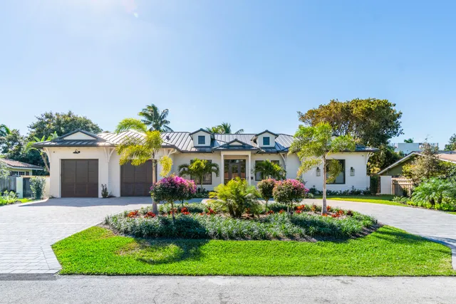 a front view of a house with a garden and plants