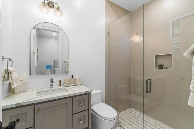 a bathroom with a sink a toilet and shower