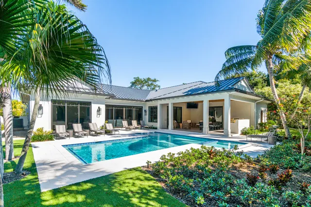 a front view of a house with swimming pool and sitting area
