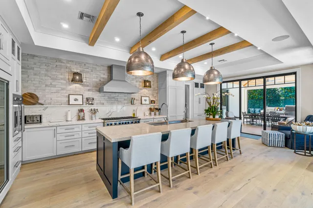 a kitchen with stainless steel appliances granite countertop a stove and chairs