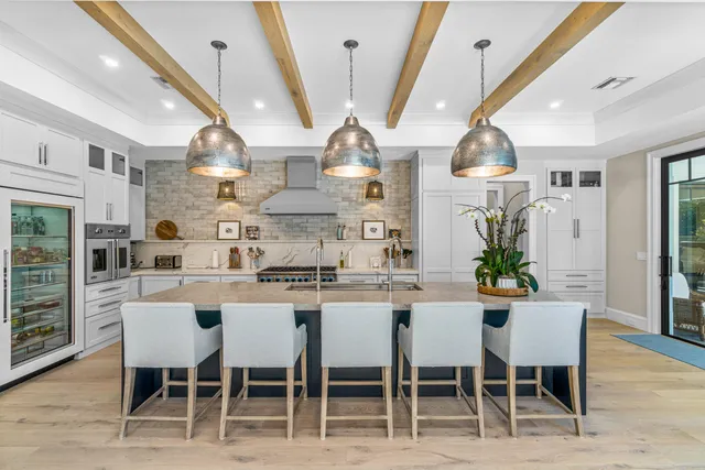 a kitchen with stainless steel appliances a dining table chairs and wooden floor