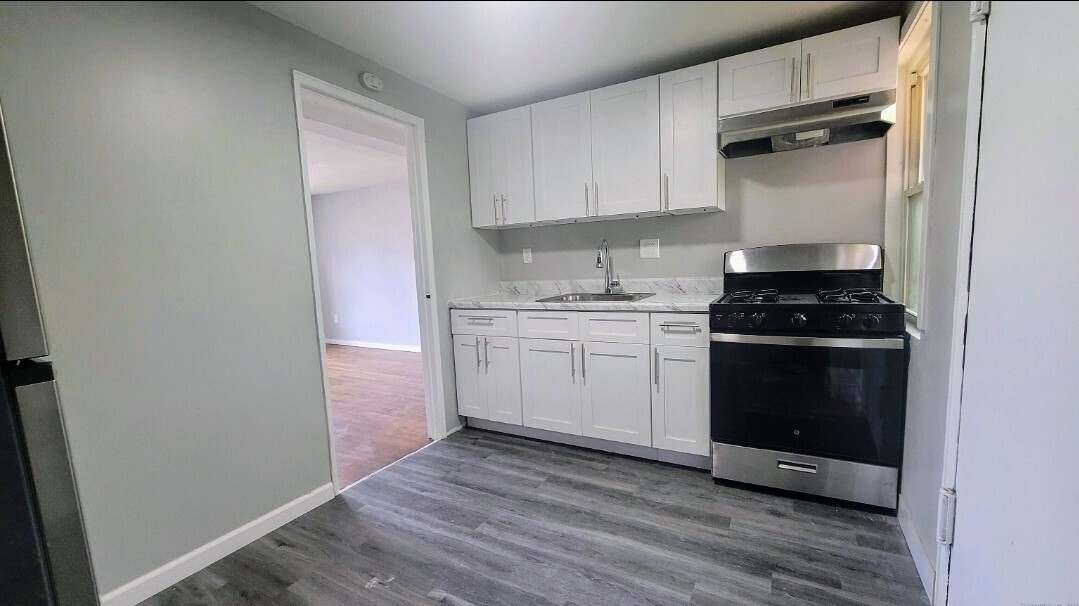 936 Wethersfield Avenue, Unit 3 Hartford, CT 06114 - Photo 2 of 5 a kitchen with a sink stove and cabinets